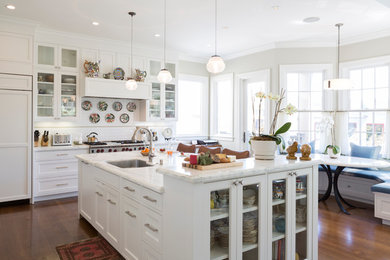 Elegant l-shaped medium tone wood floor eat-in kitchen photo in San Francisco with an undermount sink, recessed-panel cabinets, white cabinets, white backsplash, paneled appliances and an island