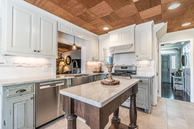 Example of a mid-sized classic l-shaped eat-in kitchen design in Other with a farmhouse sink, quartzite countertops, white backsplash, porcelain backsplash, stainless steel appliances and an island
