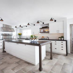 Design ideas for a mid-sized contemporary u-shaped open plan kitchen in Orange County with an undermount sink, white cabinets, white splashback, stainless steel appliances, with island, louvered cabinets, granite benchtops, brick splashback, porcelain floors and beige floor.
