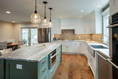 Open concept kitchen - large transitional l-shaped medium tone wood floor open concept kitchen idea in Other with a farmhouse sink, shaker cabinets, white cabinets, granite countertops, beige backsplash, glass tile backsplash, white appliances and an island