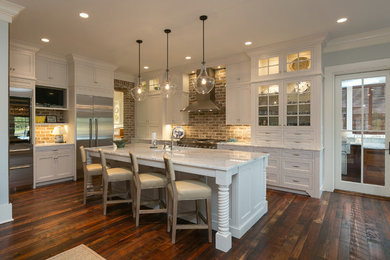 Klassische Küche in L-Form mit Schrankfronten im Shaker-Stil, weißen Schränken, Küchengeräten aus Edelstahl, dunklem Holzboden und Kücheninsel in Charleston