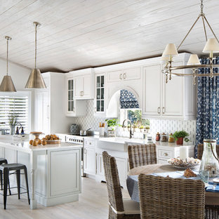 Ejemplo de cocina lineal, marinera, de tamaño medio, abierta, con fregadero sobremueble, armarios estilo shaker, puertas de armario blancas, una isla, encimera de cuarzo compacto, salpicadero multicolor, salpicadero de azulejos de vidrio, electrodomésticos de acero inoxidable y suelo de baldosas de porcelana