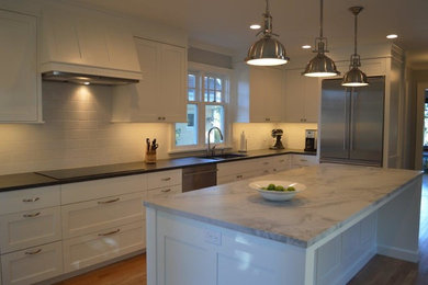 Inspiration for a transitional medium tone wood floor kitchen remodel in Seattle with an undermount sink, shaker cabinets, white cabinets, white backsplash, subway tile backsplash, stainless steel appliances and an island