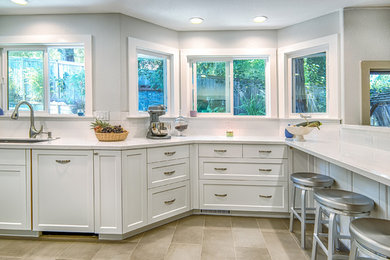 Example of a large trendy galley porcelain tile eat-in kitchen design in San Francisco with an undermount sink, shaker cabinets, white cabinets, quartz countertops, white backsplash, subway tile backsplash and paneled appliances