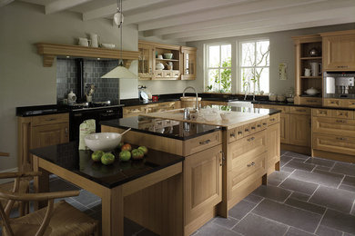 Cette photo montre une grande cuisine ouverte nature en U et bois brun avec un plan de travail en granite, un électroménager en acier inoxydable, un sol en ardoise et îlot.