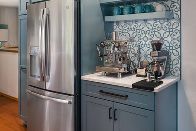 Example of an arts and crafts u-shaped kitchen design in Seattle with shaker cabinets, blue cabinets, blue backsplash, porcelain backsplash, stainless steel appliances and a peninsula