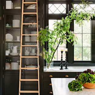 Victorian kitchen photos - Kitchen - victorian dark wood floor kitchen idea in Portland with glass-front cabinets, black cabinets, marble countertops and an island