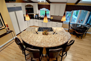 Example of a mid-sized trendy l-shaped open concept kitchen design in Minneapolis with recessed-panel cabinets, white cabinets, paneled appliances and an island