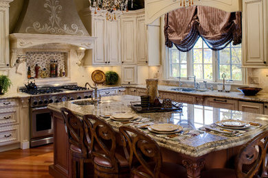 Example of a large classic l-shaped medium tone wood floor kitchen design in Chicago with a double-bowl sink, recessed-panel cabinets, white cabinets, granite countertops, beige backsplash, ceramic backsplash, stainless steel appliances and an island