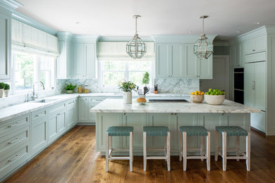 Inspiration for a timeless l-shaped medium tone wood floor kitchen remodel in Denver with an undermount sink, shaker cabinets, blue cabinets, marble countertops, white backsplash, marble backsplash, paneled appliances, an island and white countertops