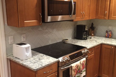 Kitchen - kitchen idea in Tampa with quartz countertops, white backsplash and glass tile backsplash