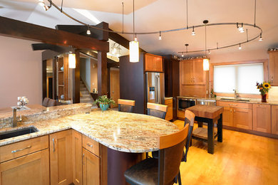 Large transitional u-shaped light wood floor and brown floor open concept kitchen photo in New York with an undermount sink, shaker cabinets, light wood cabinets, granite countertops, beige backsplash, subway tile backsplash, stainless steel appliances and a peninsula