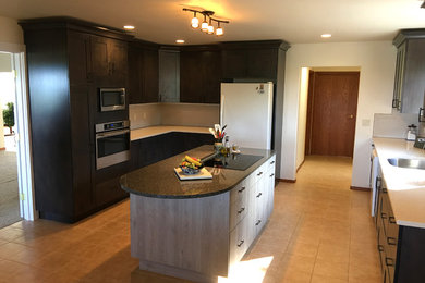 Photo of a medium sized classic l-shaped kitchen/diner in Seattle with a single-bowl sink, shaker cabinets, dark wood cabinets, quartz worktops, white splashback, porcelain splashback, stainless steel appliances, porcelain flooring and an island.