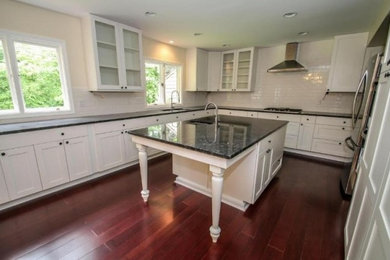 Eat-in kitchen - large contemporary bamboo floor eat-in kitchen idea in Milwaukee with an undermount sink, granite countertops, white backsplash, subway tile backsplash, stainless steel appliances and an island