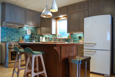 Inredning av ett klassiskt kök, med en rustik diskho, skåp i shakerstil, grå skåp, bänkskiva i kvartsit, blått stänkskydd, stänkskydd i keramik, rostfria vitvaror, ljust trägolv, en köksö och flerfärgat golv
