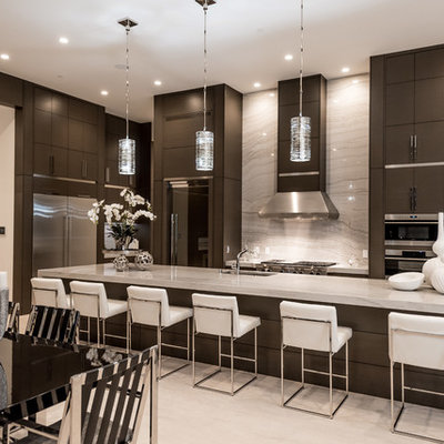 Example of a mid-sized trendy travertine floor and gray floor open concept kitchen design in Las Vegas with an undermount sink, dark wood cabinets, granite countertops, stainless steel appliances, an island, flat-panel cabinets, white backsplash and stone slab backsplash