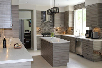 Example of a beige floor eat-in kitchen design in Other with an undermount sink, gray cabinets, quartz countertops, multicolored backsplash, glass tile backsplash, stainless steel appliances and an island