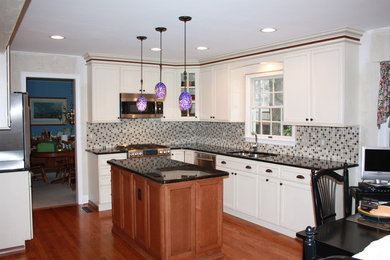Eat-in kitchen - mid-sized traditional u-shaped medium tone wood floor eat-in kitchen idea in Baltimore with an undermount sink, white cabinets, granite countertops, multicolored backsplash, stainless steel appliances, an island, recessed-panel cabinets and mosaic tile backsplash