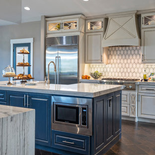 This is an example of a mid-sized beach style u-shaped open plan kitchen in Miami with a farmhouse sink, raised-panel cabinets, beige cabinets, marble benchtops, stainless steel appliances and multiple islands.