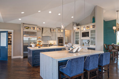 Inspiration for a mid-sized coastal u-shaped dark wood floor open concept kitchen remodel in Miami with a farmhouse sink, raised-panel cabinets, beige cabinets, marble countertops, stainless steel appliances and two islands