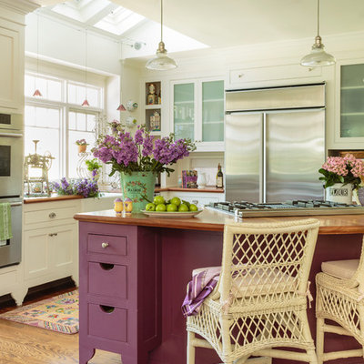 Example of a large cottage chic medium tone wood floor open concept kitchen design in Los Angeles with a farmhouse sink, white cabinets, wood countertops, white backsplash, stainless steel appliances, an island and shaker cabinets
