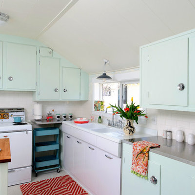 Mid-century modern enclosed kitchen photo in Other with flat-panel cabinets, subway tile backsplash, an integrated sink, stainless steel countertops, white appliances, green cabinets and white backsplash