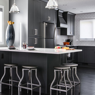 Ejemplo de cocina comedor en L, contemporánea, grande, con armarios estilo shaker, puertas de armario grises, península, fregadero bajoencimera, encimera de mármol, salpicadero amarillo, salpicadero de azulejos tipo metro, electrodomésticos de acero inoxidable y suelo de madera oscura