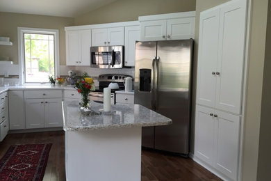 Example of a mid-sized trendy u-shaped eat-in kitchen design in Other with shaker cabinets, white cabinets, stainless steel appliances and an island