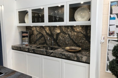 Photo of a contemporary kitchen in Other with an integrated sink, shaker cabinets, quartz worktops, multi-coloured splashback, black appliances and an island.