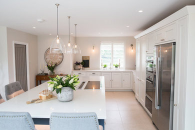 This is an example of a country kitchen in Buckinghamshire with a double-bowl sink, shaker cabinets, white cabinets, composite countertops, ceramic flooring, grey floors and white worktops.