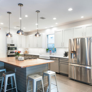 Large contemporary open concept kitchen pictures - Example of a large trendy l-shaped ceramic tile open concept kitchen design in Austin with a farmhouse sink, shaker cabinets, white cabinets, wood countertops, white backsplash, ceramic backsplash, stainless steel appliances and an island