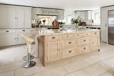 Classic kitchen in Hertfordshire with recessed-panel cabinets, beige cabinets, a breakfast bar and beige floors.