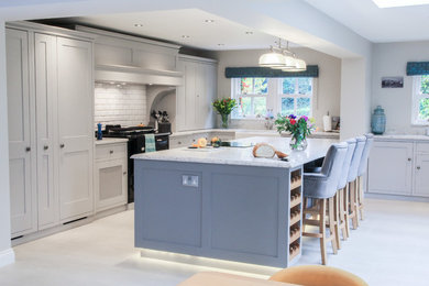 Inspiration for a large traditional l-shaped open plan kitchen in Other with a belfast sink, shaker cabinets, grey cabinets, quartz worktops, white splashback, ceramic splashback, integrated appliances, limestone flooring, an island, white floors and white worktops.