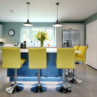 Design ideas for a large contemporary l-shaped kitchen in Other with glass sheet splashback, stainless steel appliances, an island, grey floors, white worktops, shaker cabinets, grey cabinets and green splashback.