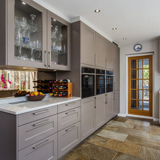 Esempio di una cucina abitabile moderna con ante in stile shaker, ante grigie, top in quarzite, paraspruzzi a effetto metallico, paraspruzzi in pietra calcarea, pavimento in travertino e top giallo
