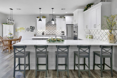 Eat-in kitchen - large traditional u-shaped eat-in kitchen idea in Phoenix with shaker cabinets, stainless steel appliances, an island and white countertops