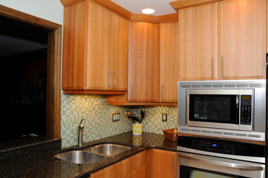 Bild på ett mellanstort funkis kök, med bänkskiva i kvartsit, stänkskydd i glaskakel, rostfria vitvaror, skåp i ljust trä, en dubbel diskho, släta luckor, blått stänkskydd och en köksö