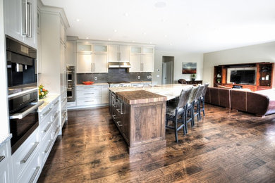 Inspiration for a transitional l-shaped open concept kitchen remodel in Calgary with stainless steel appliances and an island