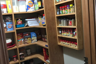 Diseño de cocinas en U tradicional pequeño con despensa, armarios con paneles lisos y puertas de armario de madera oscura