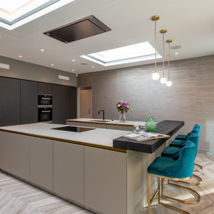 This is an example of a large contemporary u-shaped open plan kitchen in London with flat-panel cabinets, grey cabinets, ceramic flooring and multiple islands.