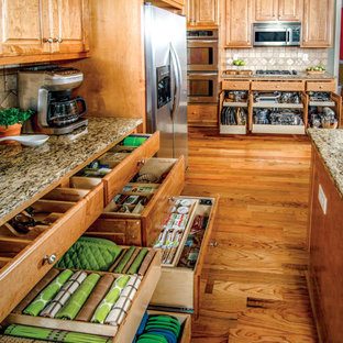 Ispirazione per una cucina ad U chic chiusa e di medie dimensioni con lavello sottopiano, top in granito, elettrodomestici in acciaio inossidabile, parquet scuro, pavimento marrone e top multicolore