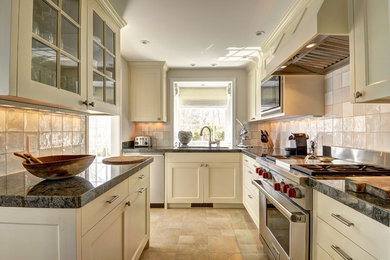 Example of a mid-sized cottage galley medium tone wood floor enclosed kitchen design in New York with recessed-panel cabinets, granite countertops, white backsplash, no island, an undermount sink, white cabinets, stainless steel appliances and glass tile backsplash