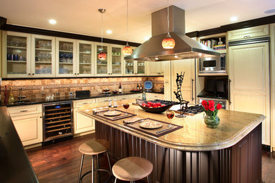 Transitional u-shaped dark wood floor eat-in kitchen photo in Los Angeles with an undermount sink, glass-front cabinets, beige cabinets, granite countertops, stainless steel appliances, multicolored backsplash and an island