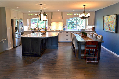 Photo of a kitchen in Edmonton with a belfast sink, shaker cabinets, white cabinets, engineered stone countertops, white splashback, dark hardwood flooring and an island.