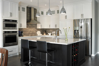 Inspiration for a mid-sized transitional l-shaped dark wood floor eat-in kitchen remodel in Calgary with an undermount sink, white cabinets, multicolored backsplash, stainless steel appliances, an island, shaker cabinets, quartzite countertops and matchstick tile backsplash