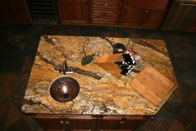 Bild på ett rustikt kök och matrum, med en undermonterad diskho, skåp i mellenmörkt trä, granitbänkskiva, skiffergolv och en köksö