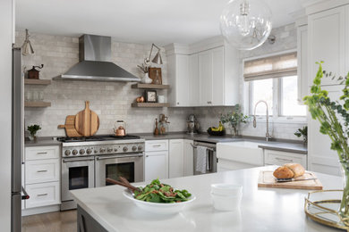 Example of a mid-sized transitional u-shaped medium tone wood floor and gray floor open concept kitchen design in Chicago with a farmhouse sink, shaker cabinets, white cabinets, quartz countertops, white backsplash, marble backsplash, stainless steel appliances, an island and gray countertops