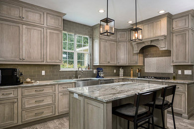 Example of a large arts and crafts l-shaped porcelain tile and gray floor kitchen design in Other with a farmhouse sink, shaker cabinets, gray cabinets, granite countertops, green backsplash, subway tile backsplash, stainless steel appliances and an island