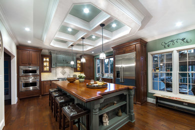 Inspiration for a large timeless u-shaped medium tone wood floor eat-in kitchen remodel in Baltimore with a farmhouse sink, raised-panel cabinets, medium tone wood cabinets, wood countertops, white backsplash, ceramic backsplash, stainless steel appliances and an island