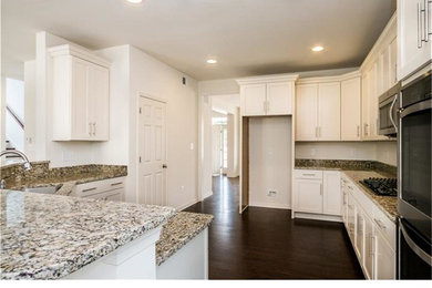 Foto på ett mellanstort funkis kök, med en undermonterad diskho, skåp i shakerstil, vita skåp, granitbänkskiva, rostfria vitvaror, mörkt trägolv och en halv köksö